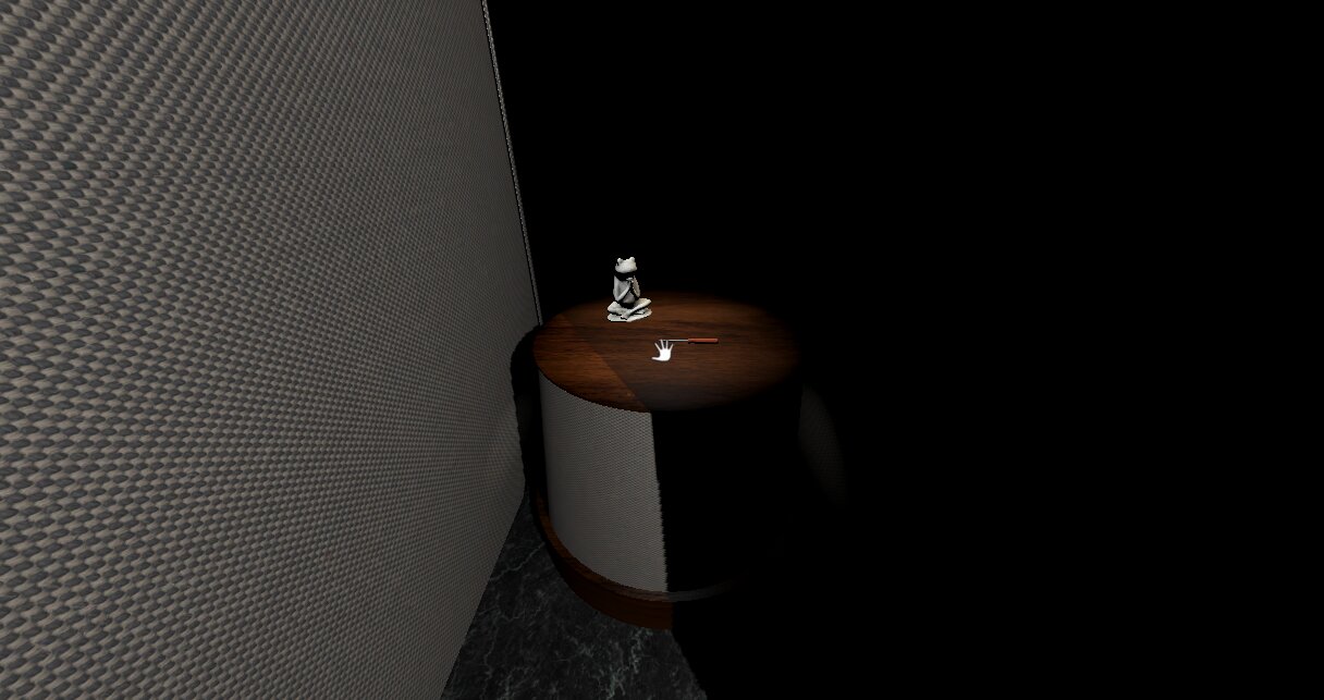 A frog statue and a screwdriver on a round wooden table in a dark corner