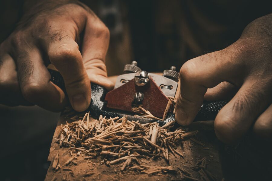 A woodworker using a spokeshave on a piece of wood